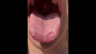 Een mooi meisje toont keel uvual en slordige natte tong