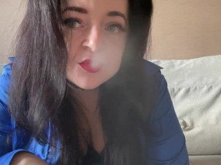 角質のmistress Laraは、セクシーな黒いコルセットに身を包んだカメラで喫煙とvapingをしています
