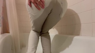 Mojando encerrado en jeans blancos. Desesperación masiva de orina