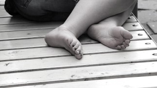 Women's feet on a park bench.