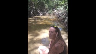 Cute long hair girl on her knees looking for shells to collect in popular spring creek part 2