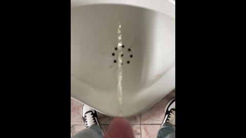 Pissing boy in a public toilet slow-mo