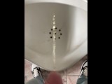 Pissing boy in a public toilet slow-mo
