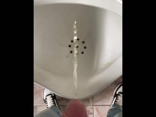 尿尿的男孩在一个公共厕所在慢动作