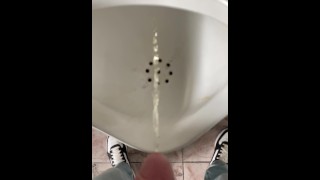 Mijar menino no banheiro público em câmera lenta