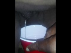 Pisses in a cup
