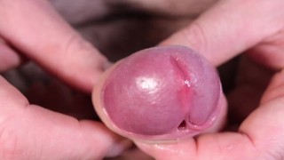 Extreme close-up en slow motion tijdens het spelen met kleine penis die het hoofd stijf maakt bloot