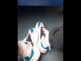 guy in jeans shows off his sneakers and white socks on the train