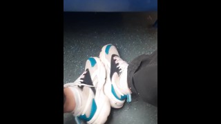 Парень в джинсах хвастается своими кроссовками и белыми носками в поезде