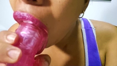 Ebony milf sucks a dildo in a very sexy way with her red lips while watching her masturbate