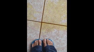 Schot van pis op de vloer en voeten van een man