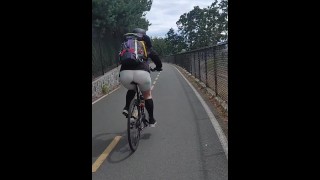 公共の自転車トレイルで自転車に乗っている肌タイツの熟女のお尻