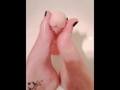Lubed up dildo gets a sloppy footjob in the shower