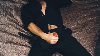 Jonge knappe man Noel Dero masturbeert op het bed in een mooi pak en brengt zichzelf tot een orgasme