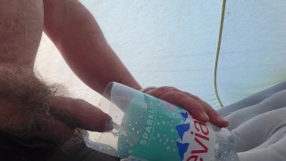 Pissen in een fles in een tent tijdens het kamperen