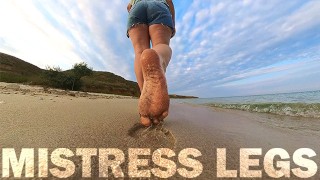 Menina descalça caminha sobre a Summer à beira-mar