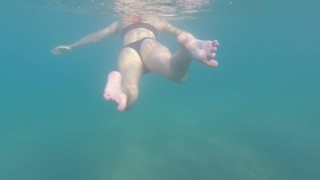 Aquatica's voeten gesmolten in de blauwe zee