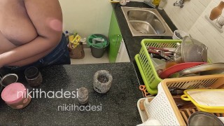 Desnuda chica lava platos en la cocina