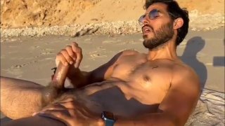 Playa pública nudista masturbándose