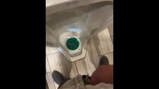 Een lek nemen in een lang urinoir bij een tankstation
