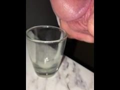 Squeezing milky cum out of the tip of my dick, shot glass collecting for cumplay, closeup