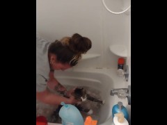 Pretty girl gives kitten a bath
