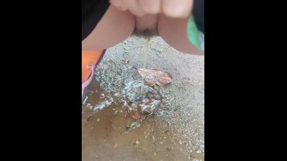 Girl Peed desperately in the rain to the puddle