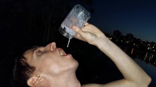 Daddy's son jerks off his meat on the riverbank and eats his sperm right after he cums in a glass