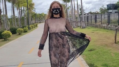 Fille lubrique dans une robe transparente dans un parc public