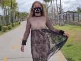 Lustful girl in a transparent dress in a public park