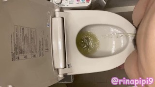 In The Restroom A Female College Student Urinates While Standing