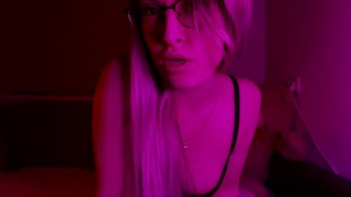 Sexy Blondine mit Brille zieht ihren BH aus