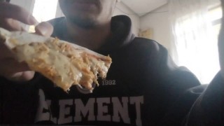 Il ragazzo mangia una pizza a pranzo