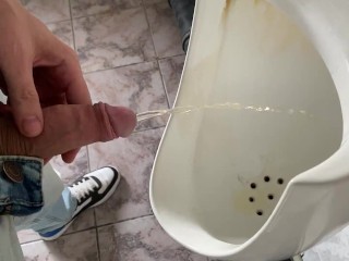 公衆便所のトイレでおしっこをするguy