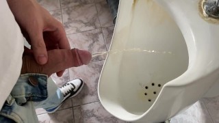Guy pisse dans les toilettes d’un bureau public