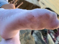 Goddess feet in dirty white socks closeup against sea sunset