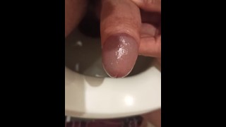 Orinado en el baño con una polla excitada.