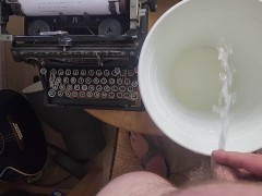 Pissing in the bucket next to typewriter spilling on the table