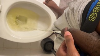 Junger schwarzer Kerl zieht Unterwäsche herunter und pisst