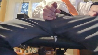 Empresário goza na cadeira do escritório de calça de terno