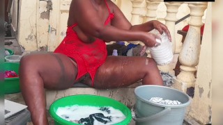 Chica africana lavando la ropa en lencería roja sin entrepierna