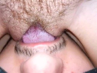 The wife moans from cunnilingus, close-up, sitting on her face with a wet pussy.