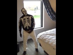 skeleton mask in pantyhose and jeans at hotel window