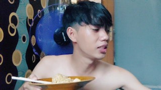 Hübscher junger Mann isst Nudeln, ohne ein T-Shirt zu tragen
