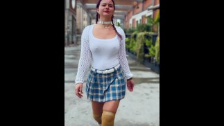 Braless brunette in a miniskirt walking the city streets.
