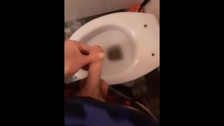 Een jonge skater pist in het toilet van een bar