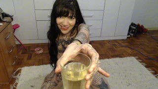 Goth fille tatouée pisse dans un verre