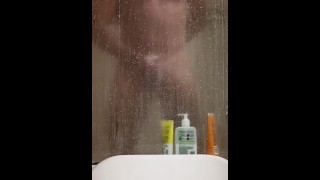 Горячий сексуальный мускулистый парень принимает душ и мастурбирует в душе спермой