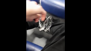 Een jonge kerel laat zijn benen zien in modieuze sneakers in de trein