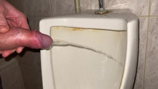 Quick pissing in a public toilet close up